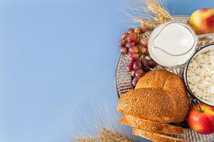 Beautiful festive background for the Jewish holiday of Shavuot with various traditional treats with a copy of the space. blue background. photo