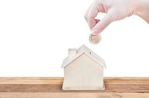 Woman hand holding coins house bank save money isolated on white background.Investment and save concept photo