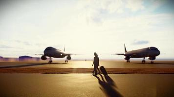 silhouette coppia a piedi con valigia su pista di decollo video