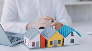 agente di intermediazione immobiliare che presenta e consulta il cliente per prendere decisioni firmare un contratto di assicurazione, acquistare e vendere modello di casa, riguardante l'offerta di mutuo ipotecario e l'assicurazione sulla casa video