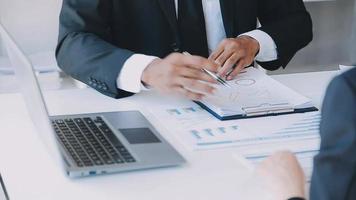 Financial analysts analyze business financial reports on a digital tablet planning investment project during a discussion at a meeting of corporate showing the results of their successful teamwork. video