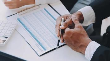 Financial analysts analyze business financial reports on a digital tablet planning investment project during a discussion at a meeting of corporate showing the results of their successful teamwork. video