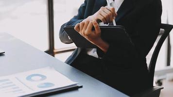 Financial analysts analyze business financial reports on a digital tablet planning investment project during a discussion at a meeting of corporate showing the results of their successful teamwork. video