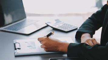 Financial analysts analyze business financial reports on a digital tablet planning investment project during a discussion at a meeting of corporate showing the results of their successful teamwork. video