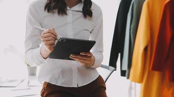 Diverse female fashion designers at work with tailor centimeters on necks and holds tablet and laptop. independent creative design business. video