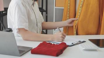 Diverse female fashion designers at work with tailor centimeters on necks and holds tablet and laptop. independent creative design business video