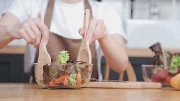 Jeune et content femme en mangeant en bonne santé salade séance sur le table avec vert Frais Ingrédients à l'intérieur video