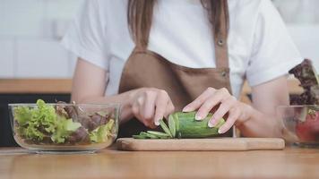 jung und glücklich Frau Essen gesund Salat Sitzung auf das Tabelle mit Grün frisch Zutaten drinnen video