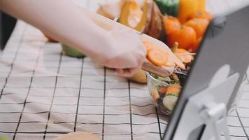 jovem e feliz mulher comendo saudável salada sentado em a mesa com verde fresco ingredientes dentro de casa video