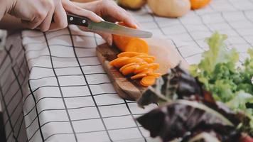 jong en gelukkig vrouw aan het eten gezond salade zittend Aan de tafel met groen vers ingrediënten binnenshuis video