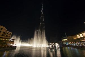 DUBAI, UAE - OCTOBER 2012 Horizontal view of Burji Khalifa at night with fountain show the highest building in the world photo