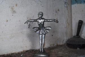 muy antiguo bailarín metálico escultura cubierto por web foto