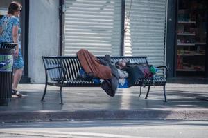 los ángeles, Estados Unidos - agosto 1, 2014 - Vagabundo dormido en un banco en caminar de fama foto