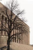 Helsinki Parliament house behind a tree with no leaves. photo