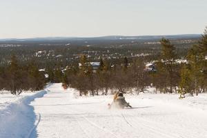 Unrecognizable people sledding down a tobogganing run in Lapland photo