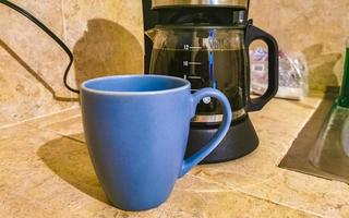 Blue coffee cup and black coffee maker from Mexico. photo