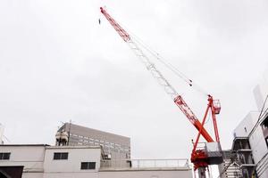 Hoisting cranes machine for move building materials at building construction site in winter sky background. photo