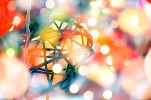 Wicker lanterns hanging in the Christmas tree on blurred and bokeh reflection lighting of lights decorating the Christmas tree around beautifully. photo