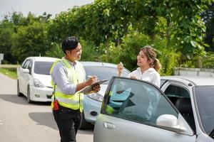 Closeup insurance agent with customer thumbs up is a sign of great work and hold a work list clipboard on outdoor background. photo