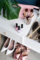 closeup of elegant high heel shoes standing under feminine dressing table photo