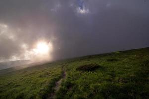 Radiation fog above grass hill landscape photo