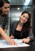 Both of young female entrepreneurs. Is exchanging ideas with new work that is going to be presented to executive management photo