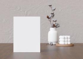 White book cover mock up with vase and candle on sideboard. Blank template for your design. Front view, close-up. Book, catalogue cover presentation. 3D rendering. photo