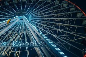 Colorful ferris wheel at night, close view photo