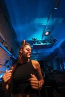 hermosa mujer dj bailando techno en un pequeño club foto