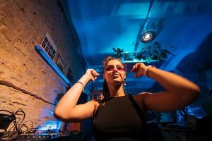 Beautiful female DJ dancing to techno in a small club photo