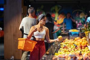 young woman do shopping in supermarket. choosing apples in store photo