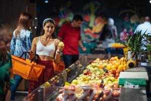 young woman do shopping in supermarket. choosing apples in store photo