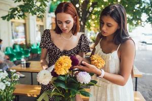 Two young women make up a beautiful festive bouquet. photo