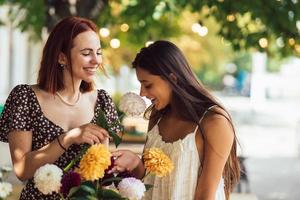 dos mujeres jóvenes componen un hermoso ramo festivo. foto