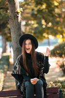 Young woman on a bench in the autumn park photo