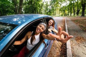 Two girlfriends fool around and laughing together in a car photo