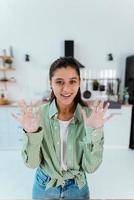 Young woman shows her hands in flour in the kitchen photo