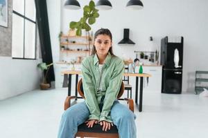 Woman sitting on a chair in a modern kitchen photo