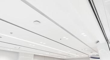 aire acondicionado tipo casete montado en el techo y luz de lámpara moderna en el techo blanco. aire acondicionado por conductos para casa u oficina foto