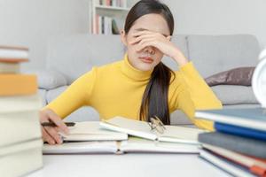 Asian student woman have anxiety because of exams, female prepare for test and learning lessons in the library. stress, despair, haste, misunderstanding reading, discouraged, expectation, knowledge photo