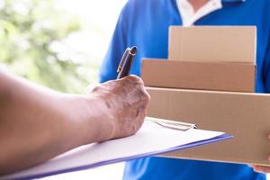 el del propietario mano es firma a recibir el paquete o empaquetar expedido por entrega hombre. foto