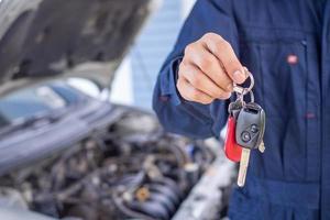 el motor ingeniero regresó el coche llave a el propietario después comprobación y fijación el coche. Fuera del sitio Servicio foto