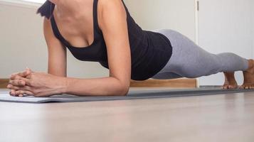 Exercise girl with strong posture wearing exercise clothes sports doing exercises, Practicing at home in the living room with a comfortable interior. photo