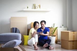 A happy young Asian couple is moving to a new home. photo