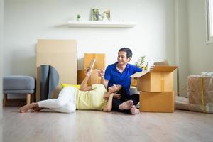 Couple sitting and resting after the tiredness of moving boxs into the house. Wife lying on lap of husband looking at photos and feeling happy. Move house, Moving out , Moving in ideas