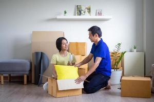 Couples helping each other to store items into the new house, Sitting and talking on the floor the wife smiled happily for her husband. New house moving ideas photo