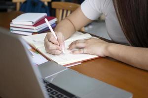 College students studying and making reports There are touch computers and books in the library for researching. photo