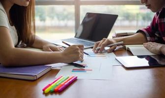 A group of Asian students sit and do homework and report in the library. photo