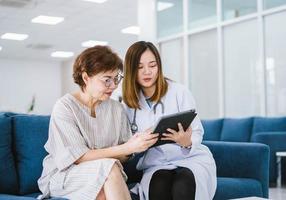 médico joven que consulta a un paciente mayor en la clínica de atención médica foto