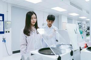 young female scientists open centrifuge in medical laboratory photo